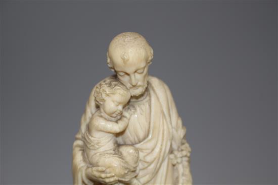 A 19th century Dieppe carved ivory figure of St Joseph holding the Christ child, 16cm, on ebony socle, overall height 26.5cm